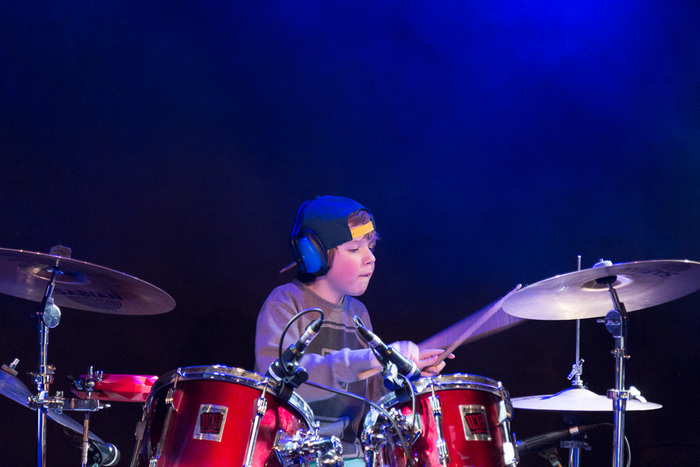 Op de foto een geconcentreerde jonge drummer die aan het drummen is