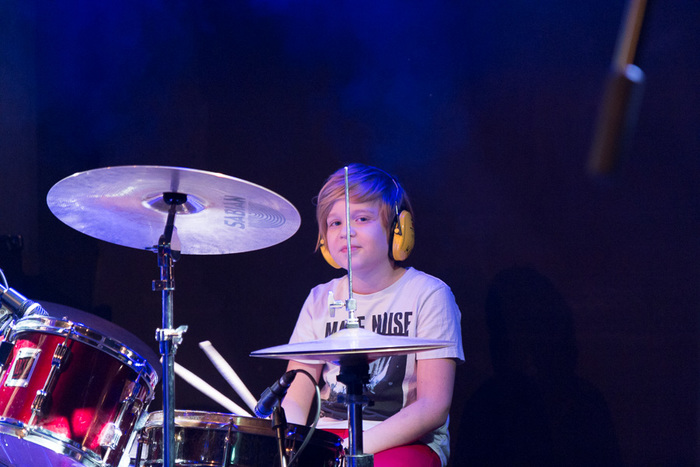 Op de foto zit een jonge drummer zenuwachtig achter zijn drumstel