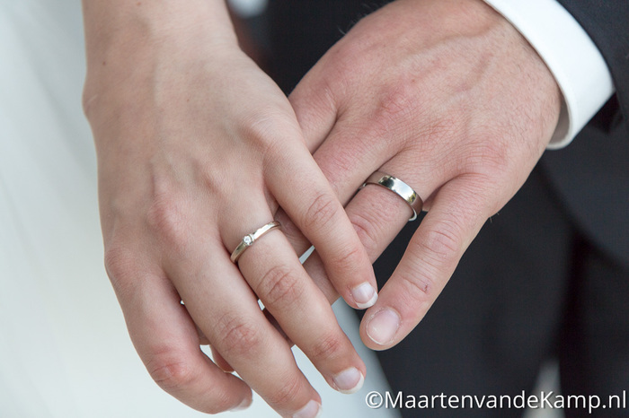De hand van de bruid en de bruidegom, met de trouwringen